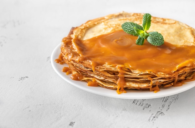 Stack of homemade crepes topped with caramel