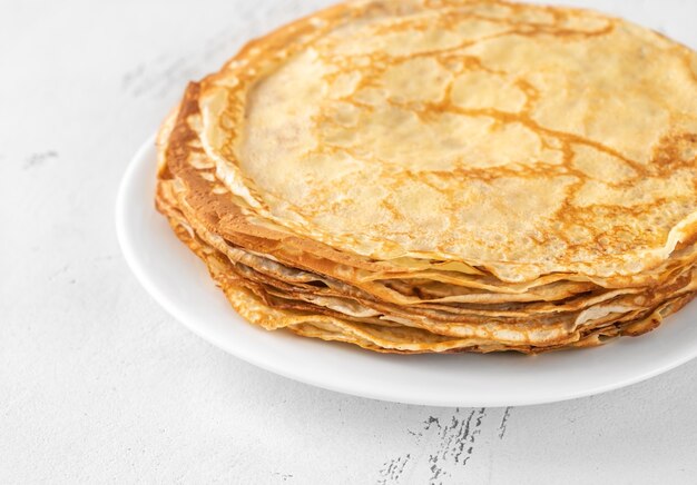 Stack of homemade crepes on the white plate