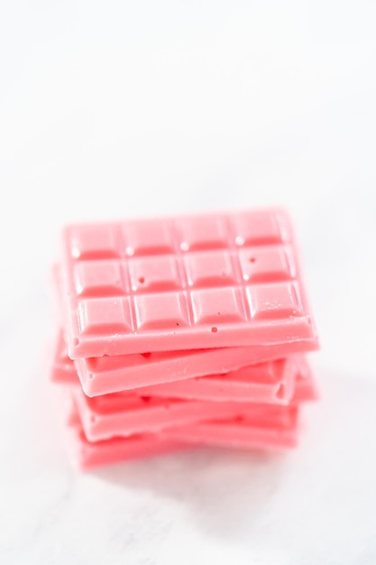 Stack of homemade mini pink chocolates on the counter.