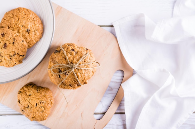 自家製のオートミール レーズン クッキーのスタックは、ボード上の文字列で結ばれています 健康的なベーキング トップ ビュー