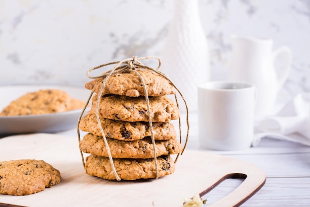 A stack of homemade oatmeal raisin cookies tied with string on a board Healthy baking