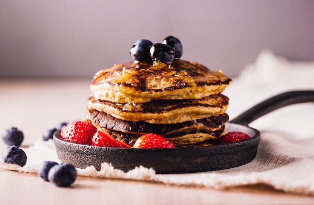 Stack of homemade pancakes with blueberries and strawberries, perfect for breakfast