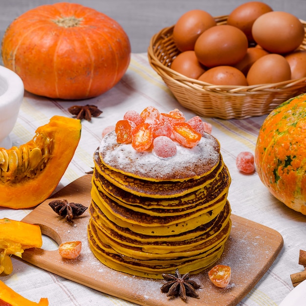 A stack of homemade pumpkin punkcakes with powdered sugar and candied kumquat 