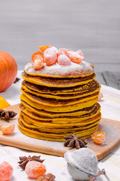 Photo a stack of homemade pumpkin punkcakes with powdered sugar and candied kumquat