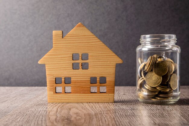 stack of house with money coins and calculator on table