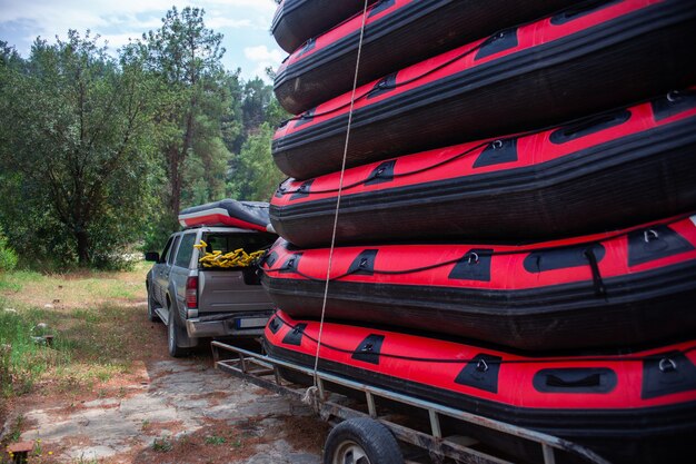 Photo stack of inflatable rafting boats near the car