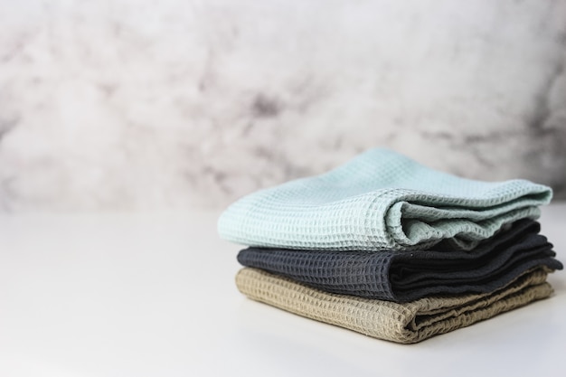 Stack kitchen cotton towels on gray background.