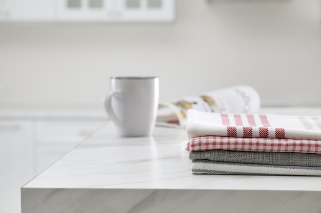 Stack of kitchen towels on white marble table Space for text