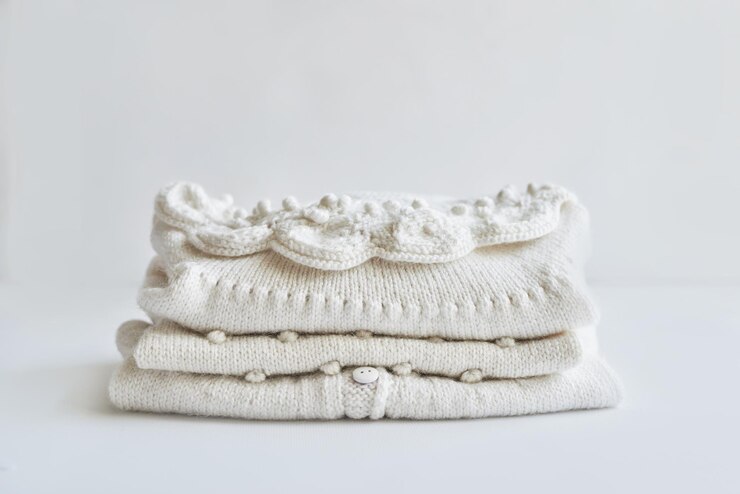 Stack of knitted clothes Baby clothes Needlework hobby knitting handwork