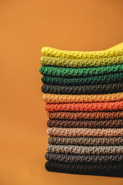 Stack of knitted material from multicolored threads on a orange background
