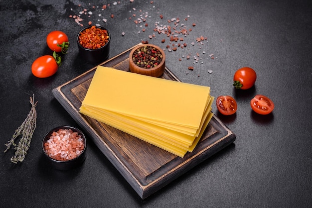 Stack of lasagna sheets on a dark concrete background Ingredients for lasagna