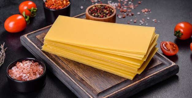 Stack of lasagna sheets on a dark concrete background Ingredients for lasagna