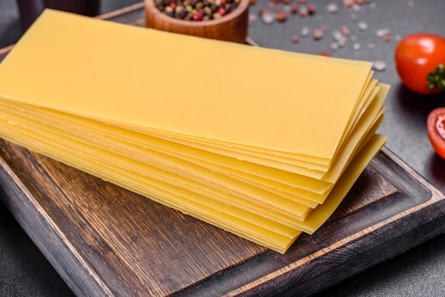 Stack of lasagna sheets on a dark concrete background Ingredients for lasagna