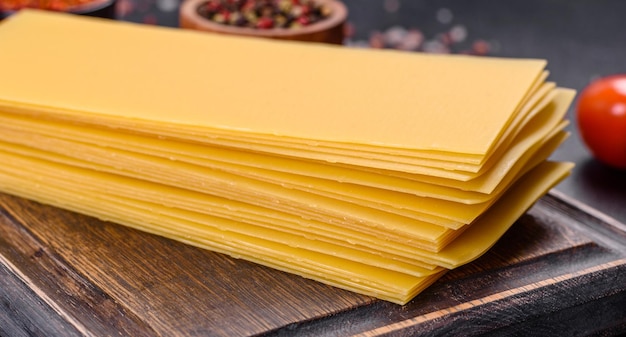 Stack of lasagna sheets on a dark concrete background Ingredients for lasagna