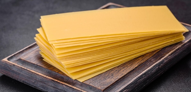 Stack of lasagna sheets on a dark concrete background Ingredients for lasagna