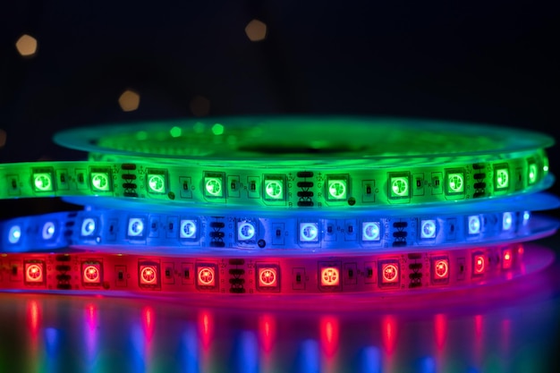 Foto una pila di luci a led in strisce luminose flessibili arrotolate, di colore verde, rosso e blu