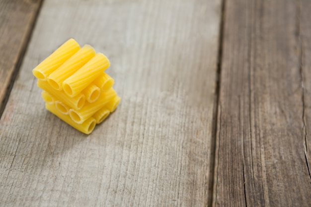 Stack of macaroni pasta on wooden surface