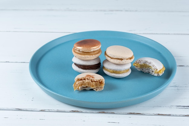 Stack of macarons filled with dulce de leche and chocolate ganache next to two macarons with bites