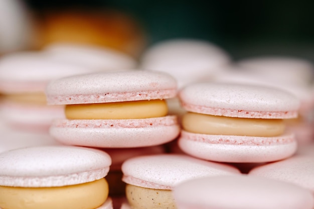 A stack of macaroons with one that has a pink color on it.
