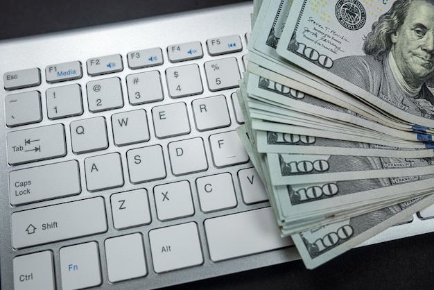 Photo stack of many american dollars on a white laptop keyboard