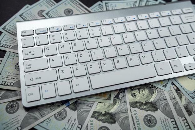 Photo stack of many american dollars on a white laptop keyboard