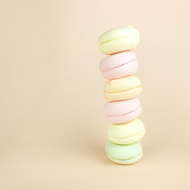 Stack of marshmallows looks like macarons macaroons French cookie on pastel cream background colorful almond cookies pastel colors