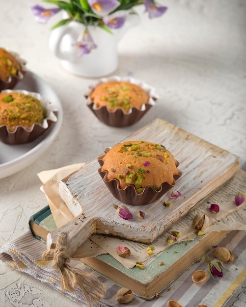 A stack of muffins with a cup of pistachio on top.