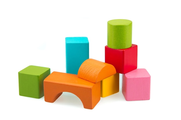 Столб многоцветных игрушечных блоков на белом фоне