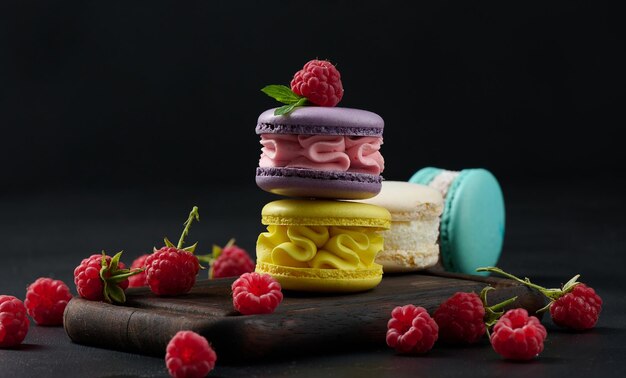 A stack of multicolored macaroons on a wooden board