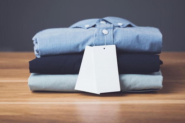 Stack of new color men shirt on wooden desk with dark space grey background Mens fashion clothing concept