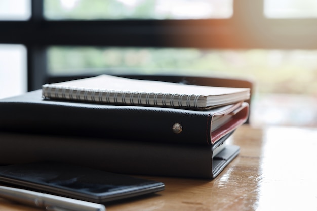 Stack of notebooks and pens on office desk