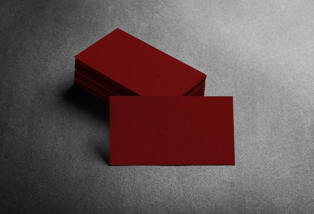 Фото Стек пустой темно-красной визитной карточки на сером текстурированном фоне вид сверху идентифицируют дизайн корпоративного ...