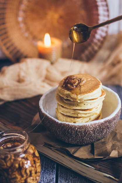 Фото Стопка вкусных блинов с медом, орехами на деревянном фоне