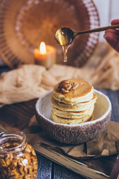 Фото Стопка вкусных блинов с медом, орехами на деревянном фоне