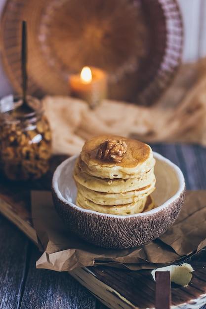 Фото Стопка вкусных блинов с медом, орехами на деревянном фоне