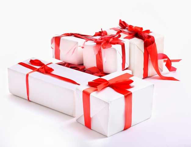 Фото Стек красных подарочных коробок, украшенных бантом, изолированным на белом