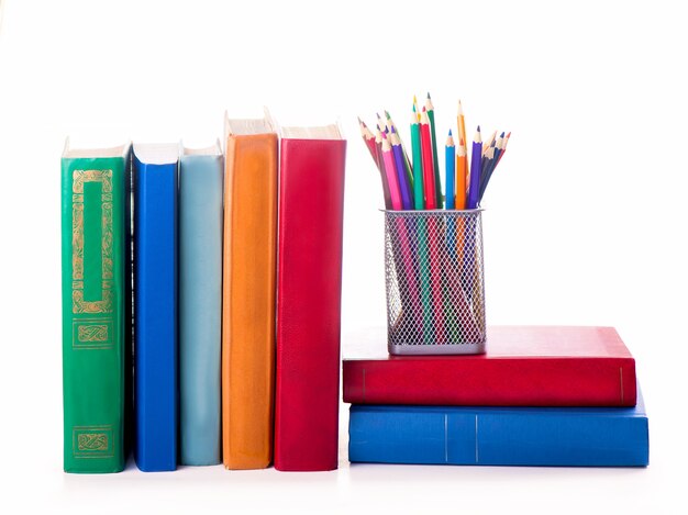 stack of old books and color pencils isolated on white