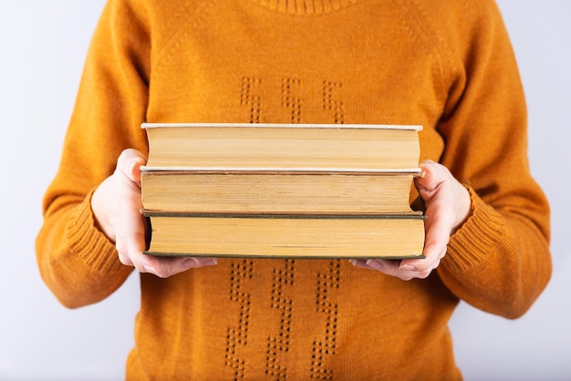 Stack of old books in the hands of a girl education learning study culture