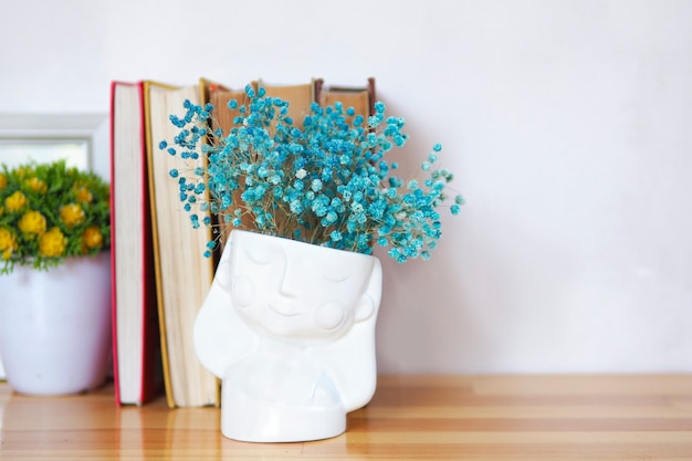 A stack of old books with vases of flowers. copy space.