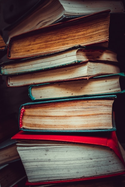 A stack of old paper books. Faded paper pages.