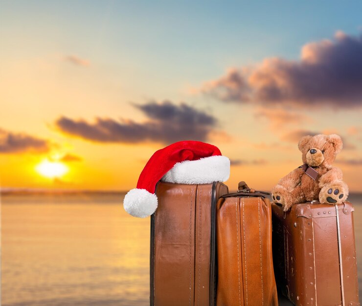 Photo stack of old suitcases with teddy bear and santa hat . travelling concept