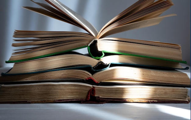 A stack of open books on a light background the concept of reading books on paper