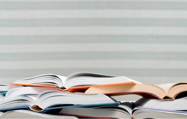 Stack of open school books on library background