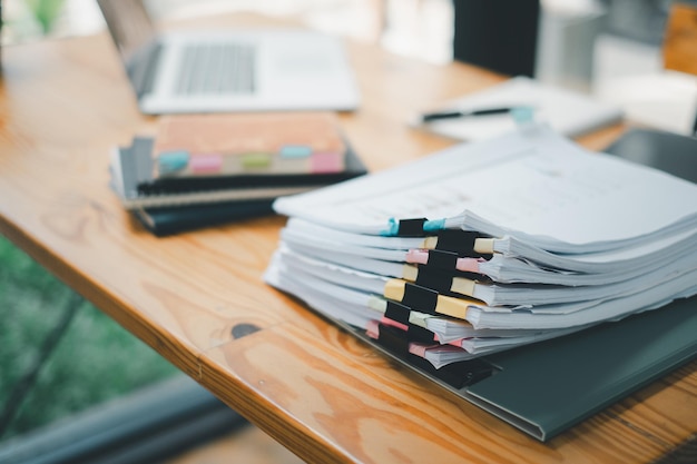 Stack overload document report paper with colorful paperclip place on office desk paperless business concept