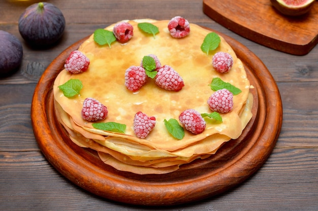 Stack of pancakes for carnival day decorated with berries and mint leaves