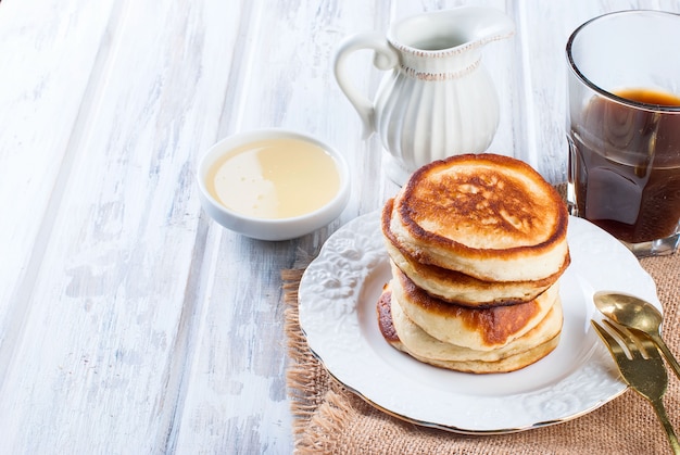 Stack of  pancakes in a dish on wooden white on 