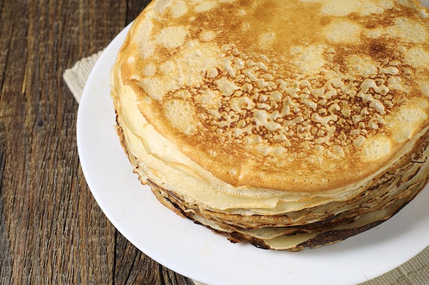 Stack of pancakes on old wooden table closeup