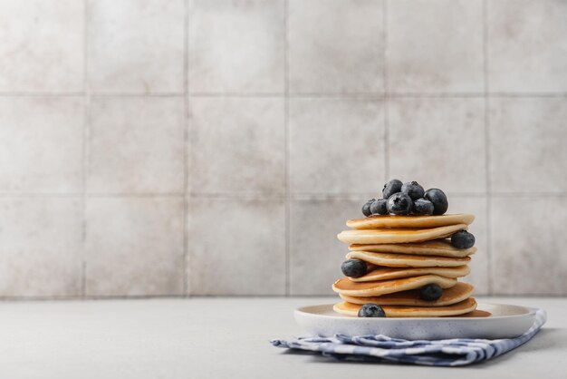 Stack of pancakes with blueberries on a white plate