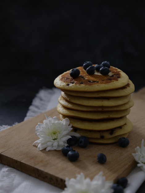 Stack of pancakes with blueberries on a wooden board