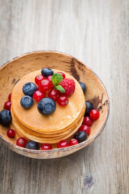 Stack of pancakes with blueberry and fresh berry.